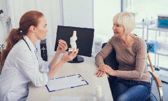 Una doctora da recomendaciones a una paciente con artritis reumatoide.