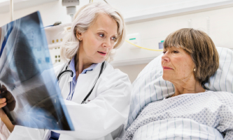 Una doctora muestra una radiografía a una paciente con cáncer de pulmón